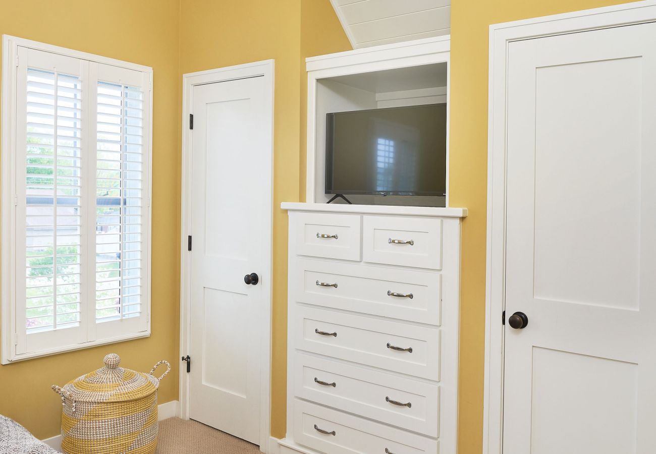 Primary bedroom with walk in closet and TV entertainment 