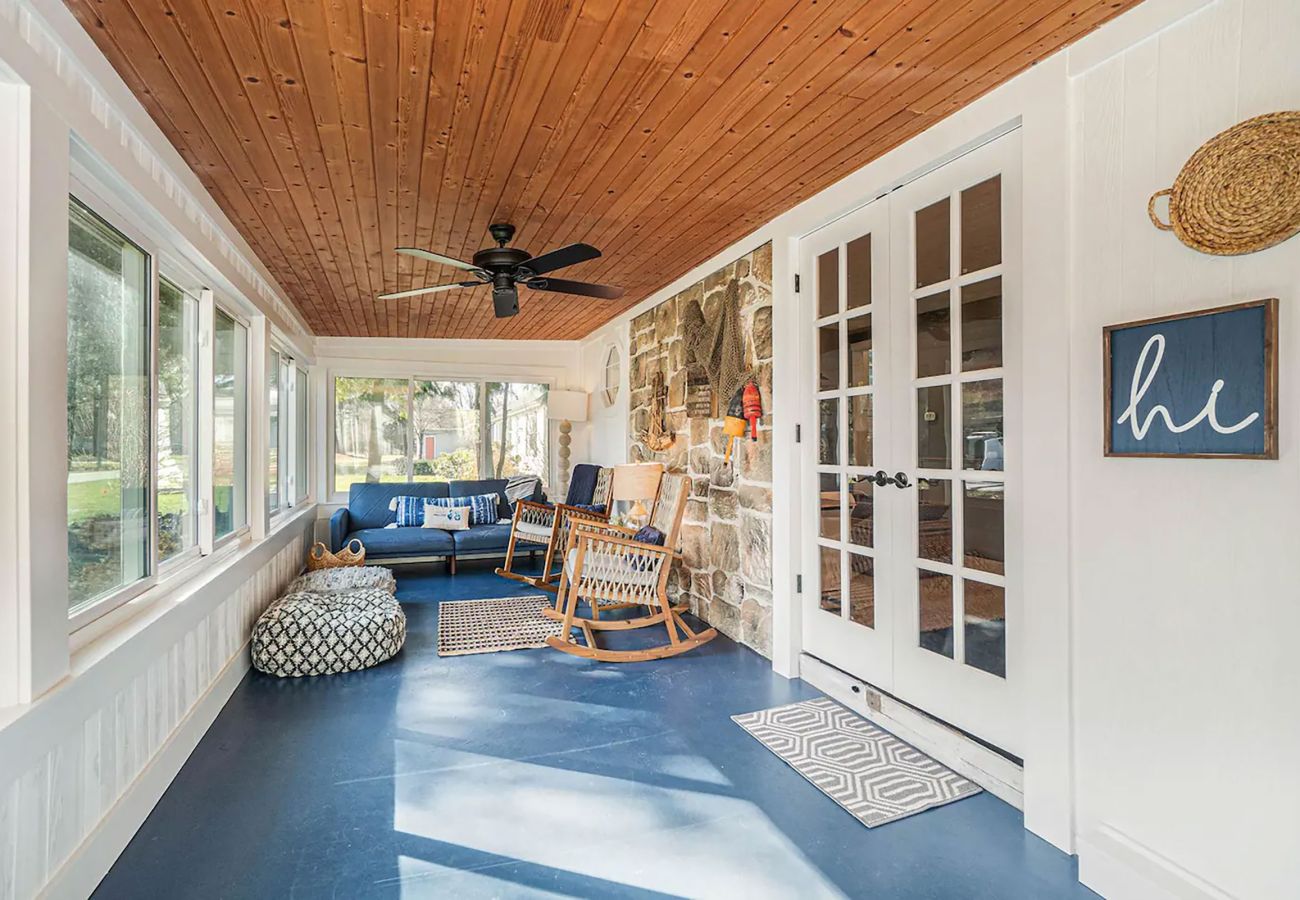 Outdoor screened in porch with seating and a perfect hangout space outside of the cottage