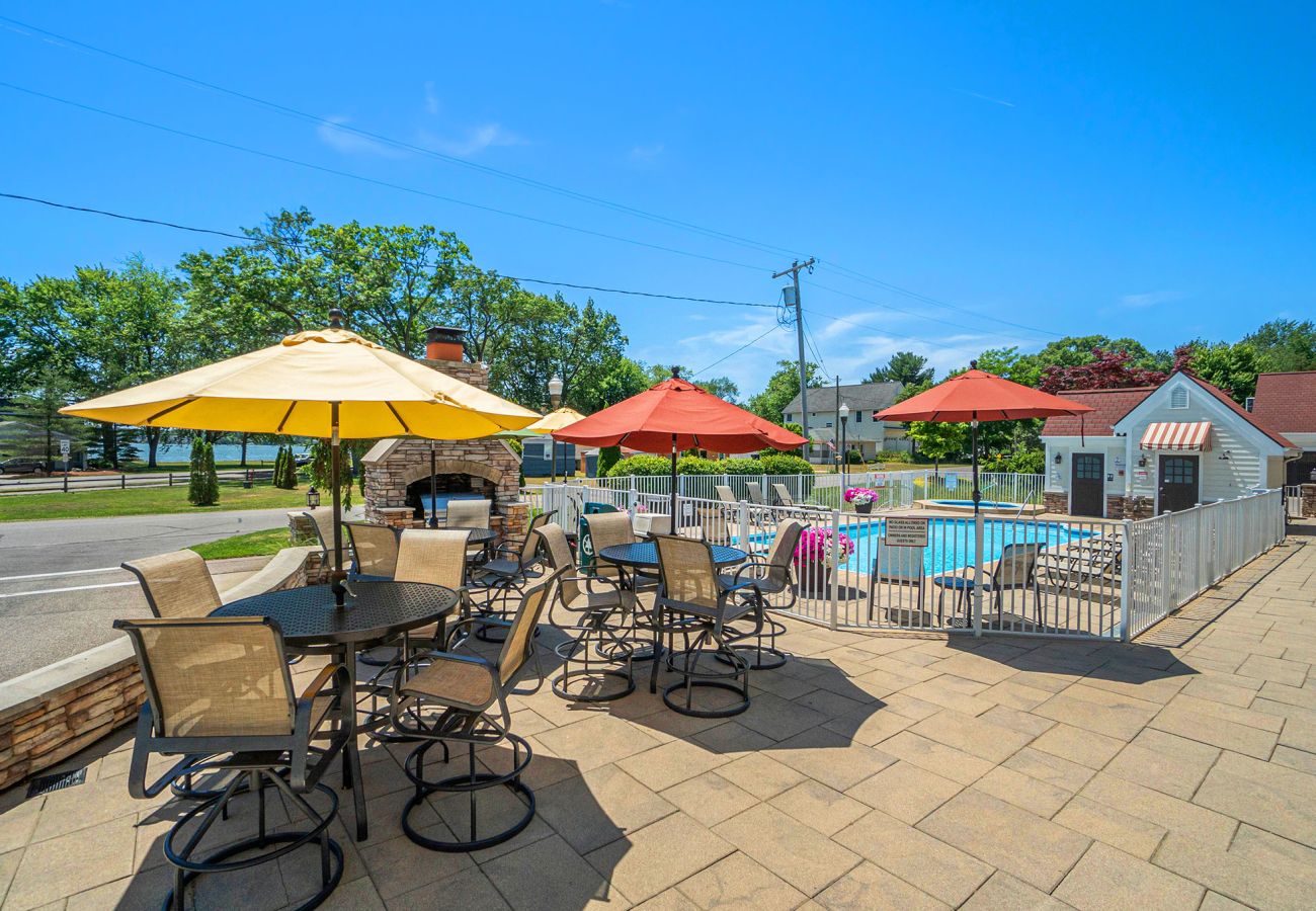 Patio and pool of the complex. Patio offers a grill and seating. Pool and hot tub also have additional outdoor seating